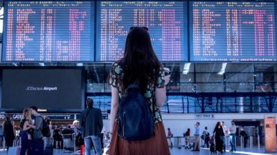 En flicka som tittar på en tidtavla på en flygplats